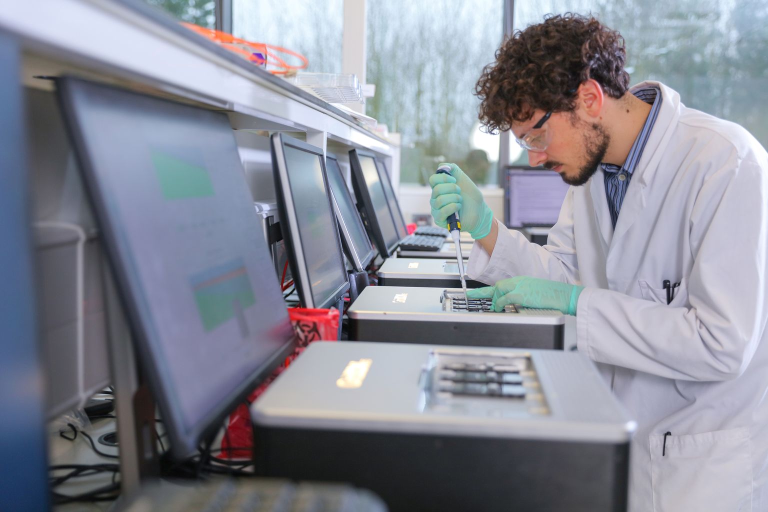 A scientist pipetting onto a GridION in a lab