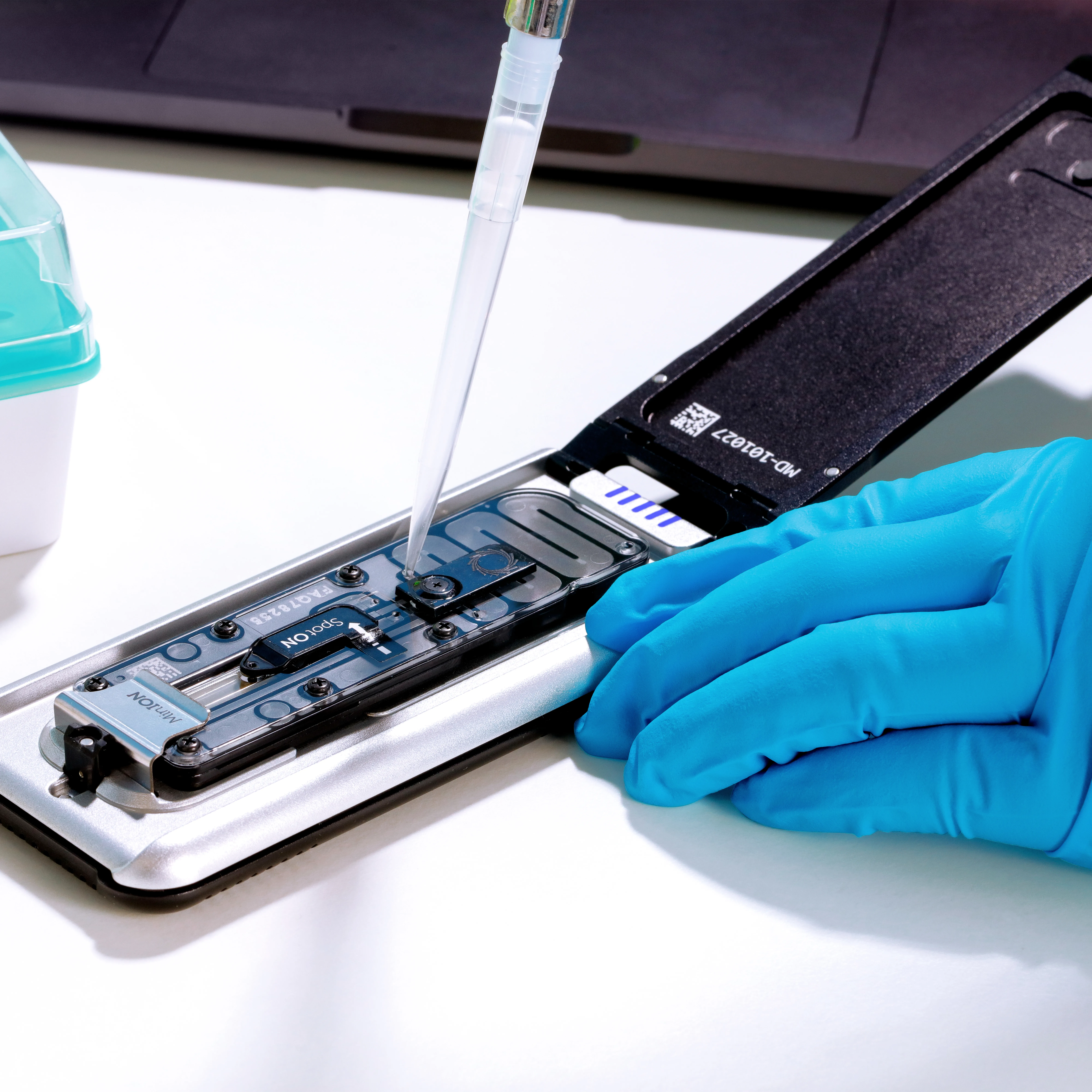 Mk1D attached to a laptop on a lab workbench - open, pipetting copy