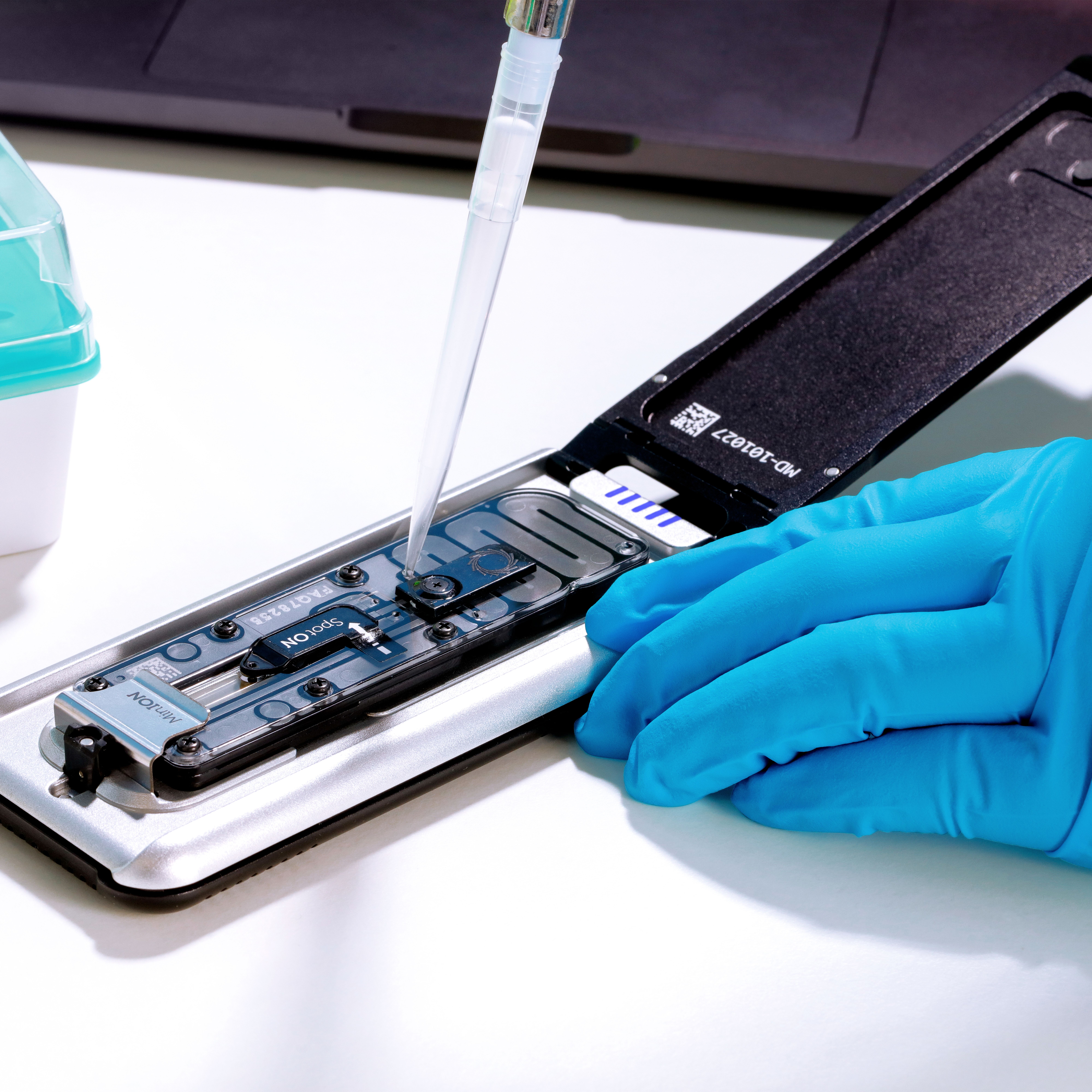 Mk1D attached to a laptop on a lab workbench - open, pipetting copy